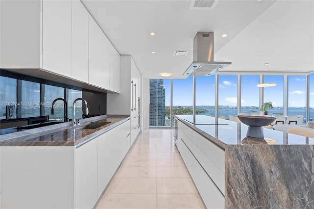 700 NE 26th Ter Unit 3101, Miami, FL 33137 - kitchen with island exhaust hood, expansive windows, white cabinets, modern cabinets, and dark stone countertops