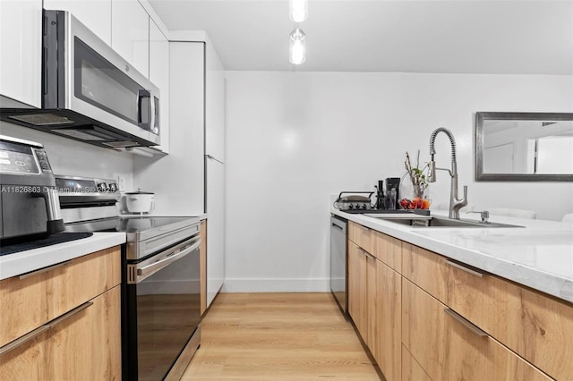 806 SW 119th Way, Davie, FL 33325 - kitchen with stainless steel appliances, light countertops, modern cabinets, light wood-style flooring, and white cabinetry