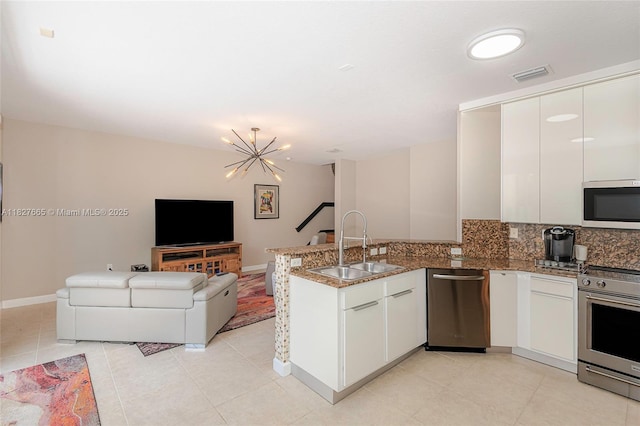 11029 NW 87th St, Doral, FL 33178 - kitchen with appliances with stainless steel finishes, a peninsula, white cabinets, open floor plan, and tasteful backsplash