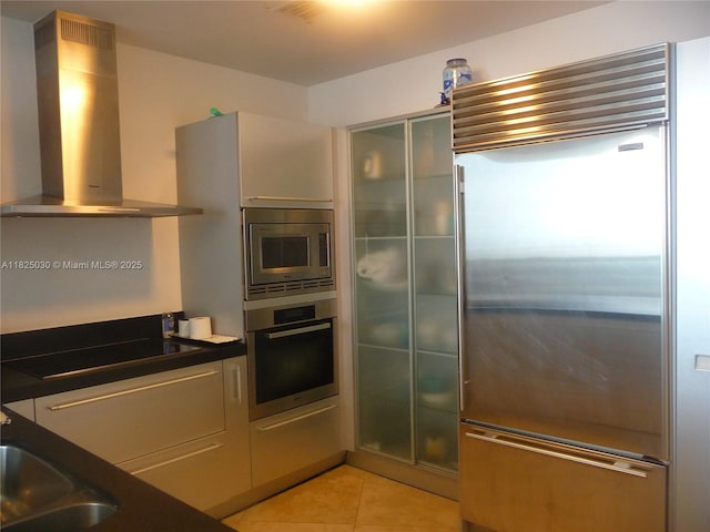 18201 Collins Ave Unit 4705, Sunny Isles Beach, FL 33160 - kitchen with built in appliances, island range hood, light tile patterned floors, and dark countertops