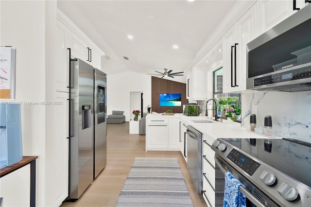 8525 NW 49th Dr, Coral Springs, FL 33067 - kitchen with stainless steel appliances, white cabinets, a ceiling fan, lofted ceiling, and light wood finished floors