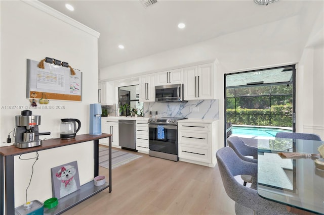 8525 NW 49th Dr, Coral Springs, FL 33067 - kitchen featuring appliances with stainless steel finishes, decorative backsplash, light countertops, white cabinetry, and recessed lighting