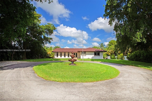 5881 SW 160th Ave, Southwest Ranches, FL 33331 - ranch-style house with curved driveway, a tiled roof, stucco siding, and a front lawn
