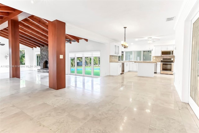 5881 SW 160th Ave, Southwest Ranches, FL 33331 - unfurnished living room featuring a stone fireplace, ceiling fan, and a chandelier