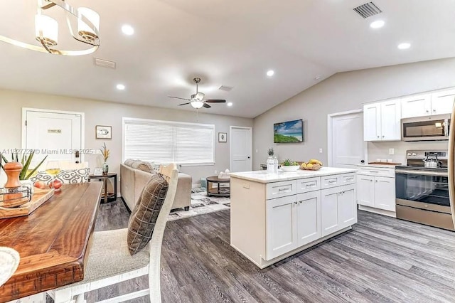 220 Kite Ave, Sebring, FL 33870 - kitchen with stainless steel appliances, dark wood-style floors, white cabinets, open floor plan, and lofted ceiling