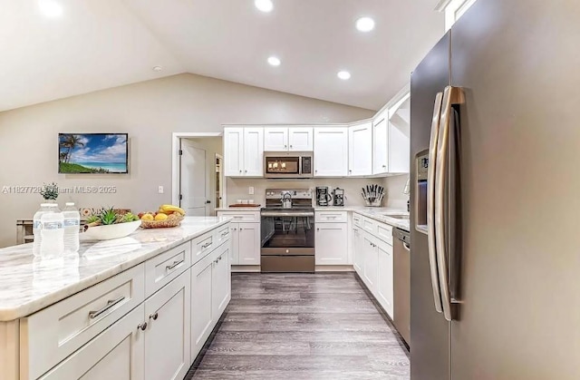 220 Kite Ave, Sebring, FL 33870 - kitchen featuring stainless steel appliances, lofted ceiling, white cabinetry, dark wood-style floors, and light stone counters