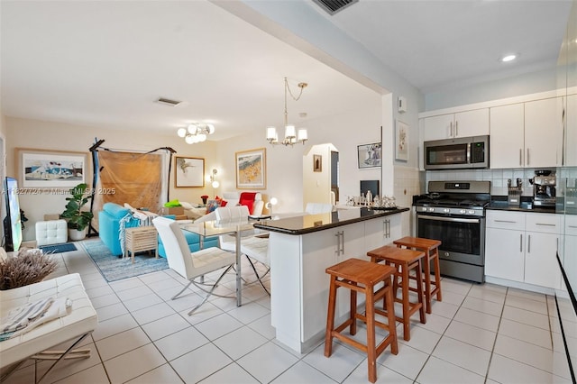 634 82nd St, Miami Beach, FL 33141 - kitchen with stainless steel appliances, open floor plan, dark countertops, light tile patterned floors, and recessed lighting