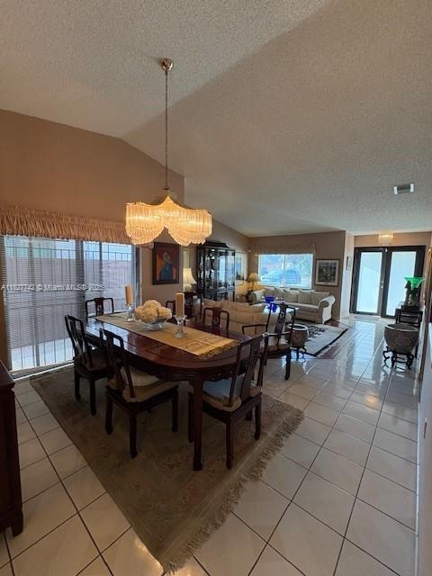 13736 SW 12th St, Miami, FL 33184 - dining room featuring light tile patterned floors, a textured ceiling, lofted ceiling, and a chandelier