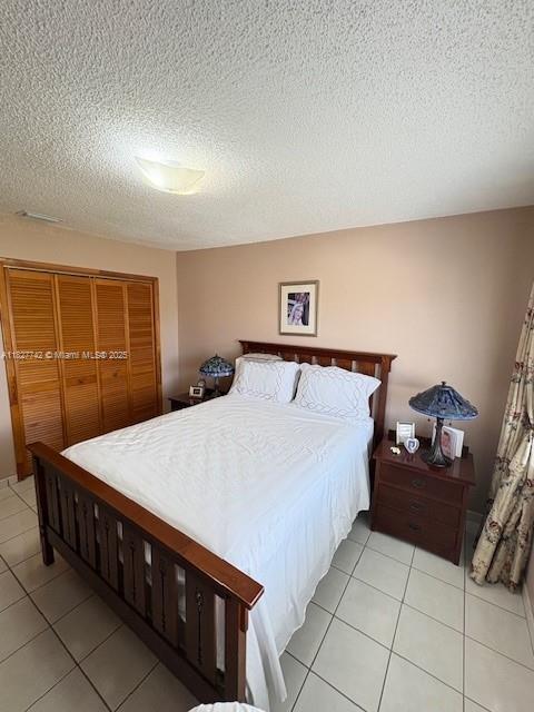13736 SW 12th St, Miami, FL 33184 - bedroom with light tile patterned floors, a textured ceiling, and a closet
