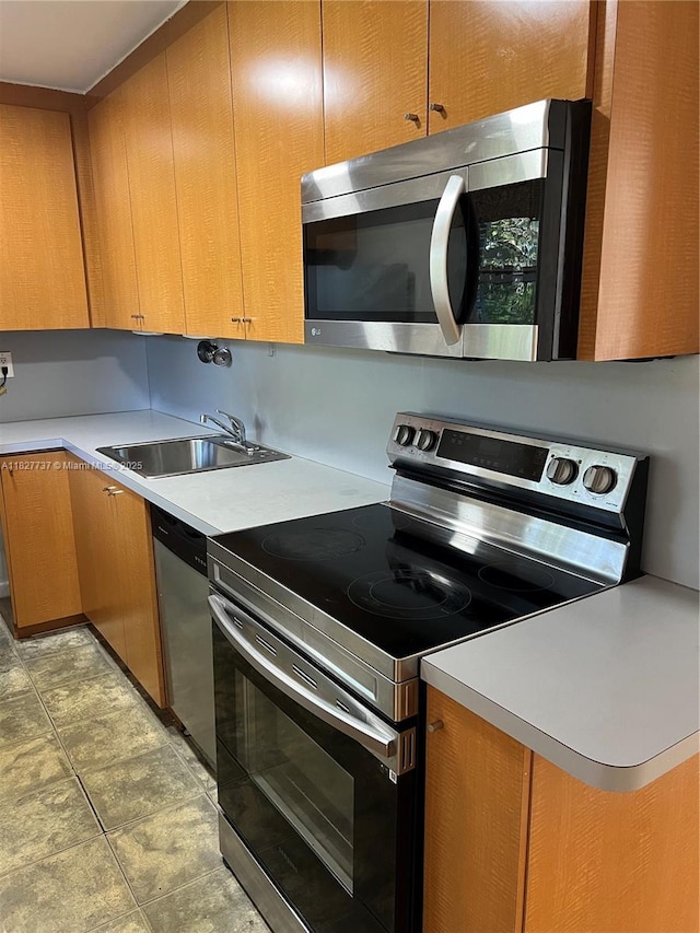645 NE 121st St Unit 404, North Miami, FL 33161 - kitchen with stainless steel appliances, light countertops, light tile patterned floors, and brown cabinetry