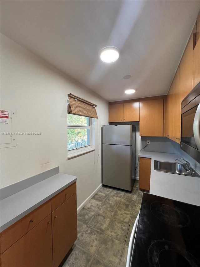 645 NE 121st St Unit 404, North Miami, FL 33161 - kitchen featuring freestanding refrigerator, light countertops, range with electric stovetop, and brown cabinetry