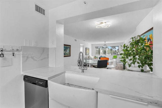 9525 Weldon Cir Unit H305, Tamarac, FL 33321 - kitchen featuring stainless steel dishwasher, light stone counters, white cabinets, and a peninsula
