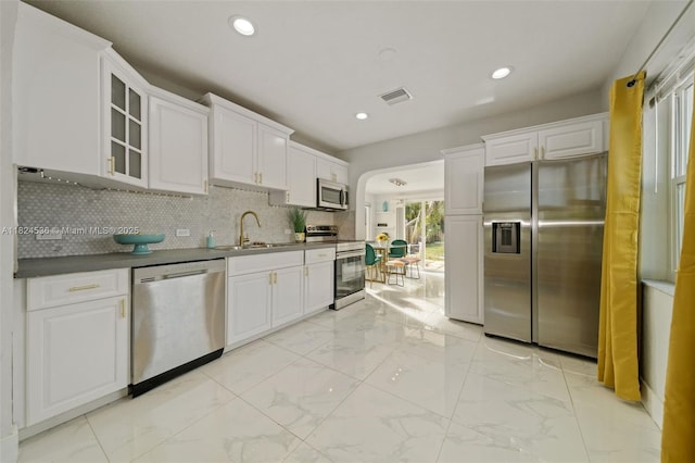 2714 Fillmore St, Hollywood, FL 33020 - kitchen with stainless steel appliances, white cabinets, light marble finish flooring, glass insert cabinets, and tasteful backsplash