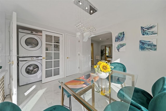 2714 Fillmore St, Hollywood, FL 33020 - dining space featuring stacked washer / dryer, marble finish floors, arched walkways, and a chandelier