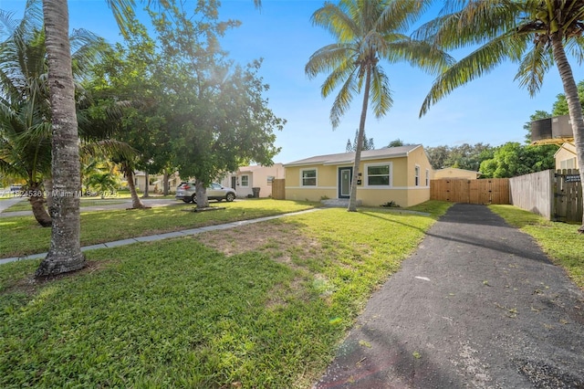 2714 Fillmore St, Hollywood, FL 33020 - view of front of house featuring stucco siding, asphalt driveway, and a gate