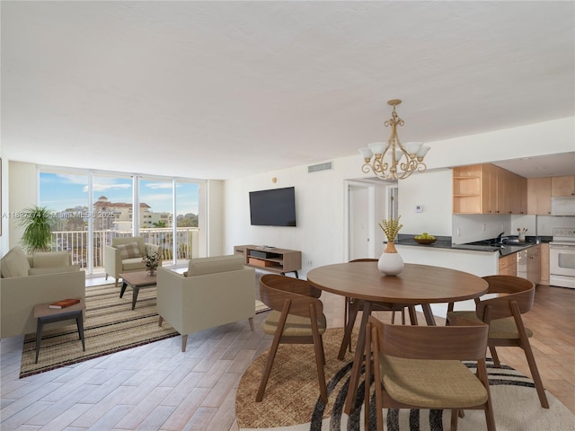 10350 W Bay Harbor Dr Unit 6L, Bay Harbor Islands, FL 33154 - dining space with light wood-style floors, a chandelier, and floor to ceiling windows