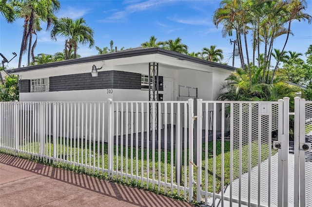 740 84th St, Miami Beach, FL 33141 - view of front facade with a fenced front yard, stucco siding, and a gate