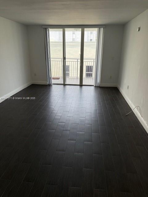 947 Lenox Ave Unit 502, Miami Beach, FL 33139 - unfurnished room featuring dark wood-style flooring and baseboards