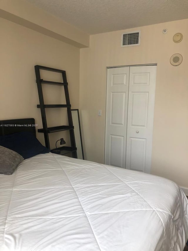 50 Menores Ave Unit 711, Coral Gables, FL 33134 - bedroom featuring a closet and a textured ceiling