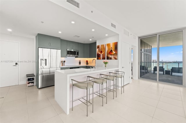 3301 NE 1st Ave Unit H2412, Miami, FL 33137 - kitchen featuring stainless steel appliances, expansive windows, light countertops, a peninsula, and a kitchen breakfast bar