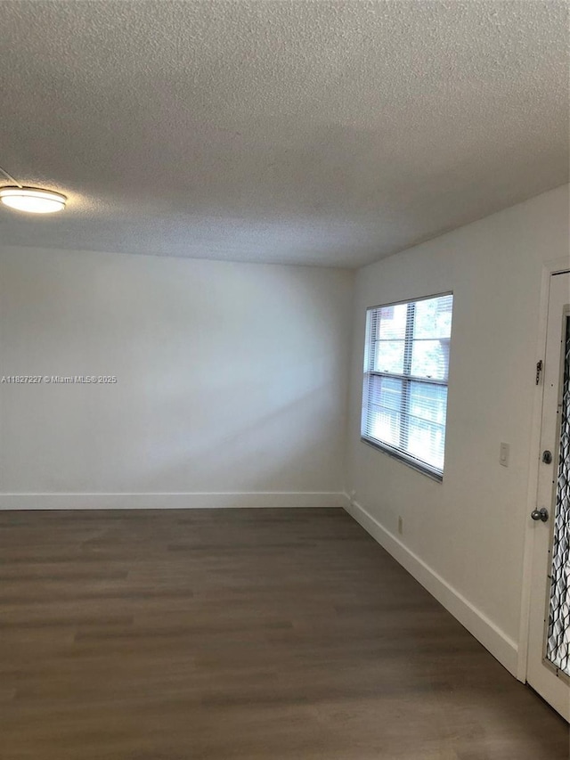850 SW 133rd Ter Unit 302B, Pembroke Pines, FL 33027 - empty room featuring a textured ceiling and dark wood-style floors