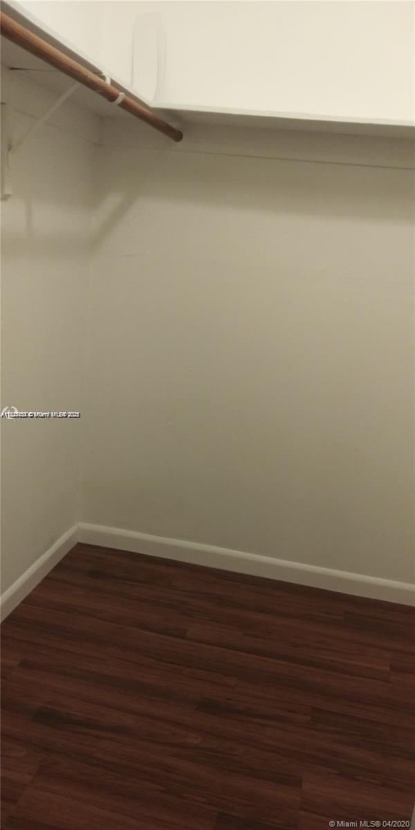 1235 Mariposa Ave Unit 8, Coral Gables, FL 33146 - walk in closet featuring dark wood finished floors