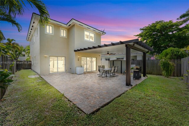 371 NE 32nd Ter, Homestead, FL 33033 - back of property at dusk with stucco siding, a fenced backyard, and a patio area
