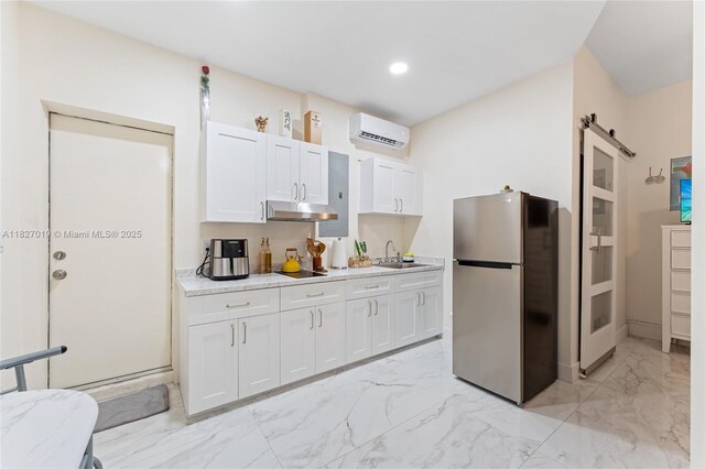 371 NE 32nd Ter, Homestead, FL 33033 - kitchen featuring freestanding refrigerator, a wall mounted air conditioner, light marble finish flooring, under cabinet range hood, and a barn door