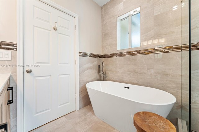 371 NE 32nd Ter, Homestead, FL 33033 - bathroom featuring tile walls, a freestanding tub, and vanity