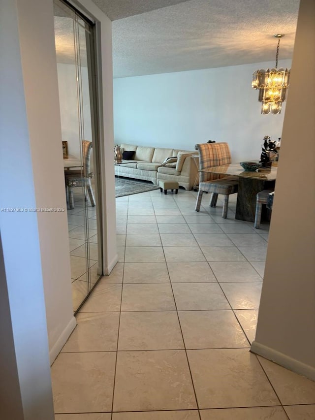 7310 Ashford Pl Unit 304, Delray Beach, FL 33446 - corridor with light tile patterned flooring, a textured ceiling, and a chandelier