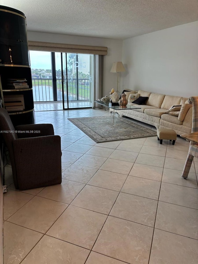 7310 Ashford Pl Unit 304, Delray Beach, FL 33446 - living room featuring a textured ceiling and light tile patterned floors
