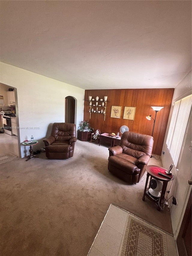 981 E 18th St, Hialeah, FL 33013 - carpeted living room featuring wooden walls and arched walkways
