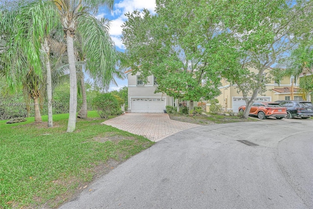 1151 W Lake St, Hollywood, FL 33019 - obstructed view of property with stucco siding, a garage, decorative driveway, and a front lawn