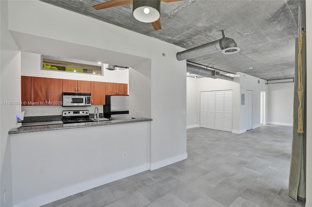 455 NE 25th St Unit 609, Miami, FL 33137 - kitchen with stainless steel appliances, a ceiling fan, dark stone countertops, a peninsula, and tile patterned floors