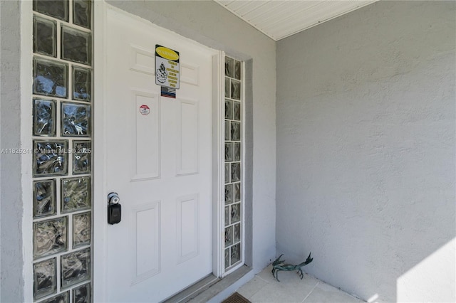 5595 Eagle Way, Merritt Island, FL 32953 - doorway to property with stucco siding and a porch