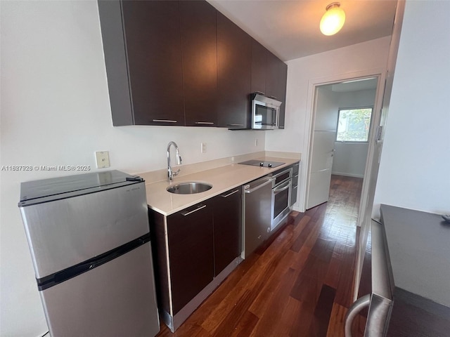1550 Pennsylvania Ave Unit 126, Miami Beach, FL 33139 - kitchen featuring appliances with stainless steel finishes, dark wood-style floors, light countertops, modern cabinets, and dark brown cabinets