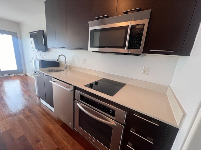 1550 Pennsylvania Ave Unit 126, Miami Beach, FL 33139 - kitchen with appliances with stainless steel finishes, modern cabinets, dark wood-style floors, light countertops, and dark cabinets