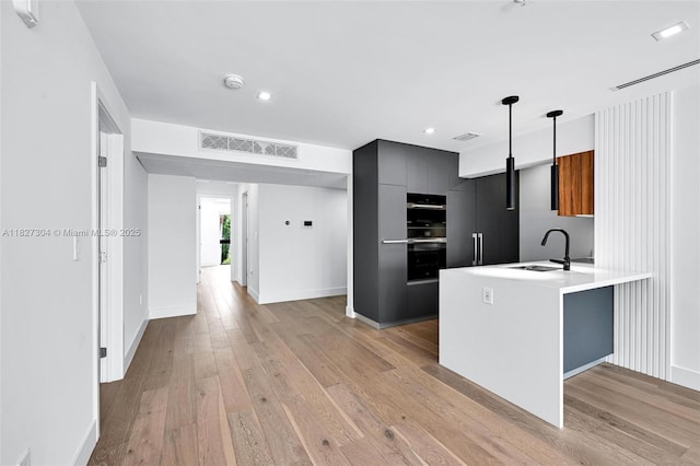 200 Sunrise Dr Unit 200C, Key Biscayne, FL 33149 - kitchen featuring stainless steel double oven, modern cabinets, a peninsula, light countertops, and light wood-style floors
