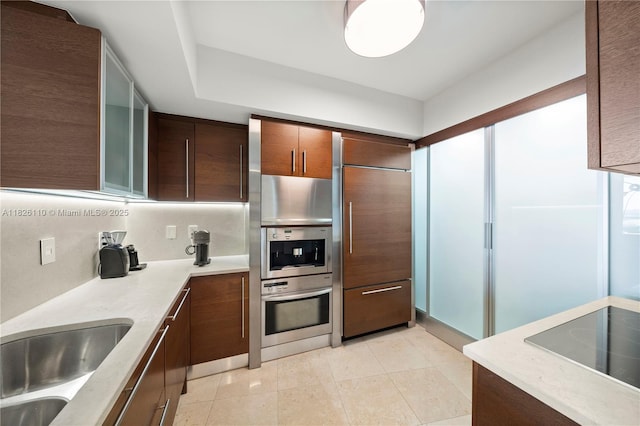 450 Alton Rd Unit 2705, Miami Beach, FL 33139 - kitchen with paneled built in fridge, light countertops, black electric stovetop, and light tile patterned flooring
