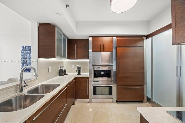 450 Alton Rd Unit 2705, Miami Beach, FL 33139 - kitchen featuring light countertops, glass insert cabinets, light tile patterned floors, double oven, and modern cabinets