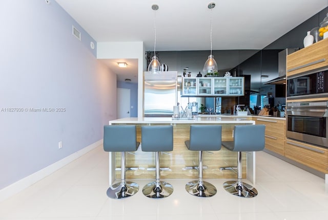 2020 N Bayshore Dr Unit 2005, Miami, FL 33137 - kitchen with stainless steel oven, modern cabinets, black microwave, light countertops, and glass insert cabinets