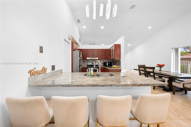4361 Mahogany Ridge Dr, Weston, FL 33331 - kitchen featuring stainless steel appliances, backsplash, a peninsula, a breakfast bar, and recessed lighting