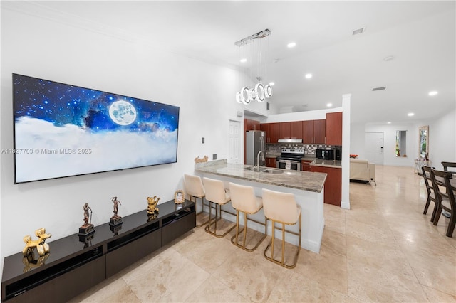 4361 Mahogany Ridge Dr, Weston, FL 33331 - kitchen with appliances with stainless steel finishes, a breakfast bar area, a peninsula, tasteful backsplash, and recessed lighting