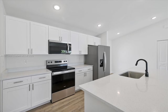 1119 NW 19th St, Cape Coral, FL 33993 - kitchen featuring stainless steel appliances, white cabinetry, light wood finished floors, and recessed lighting