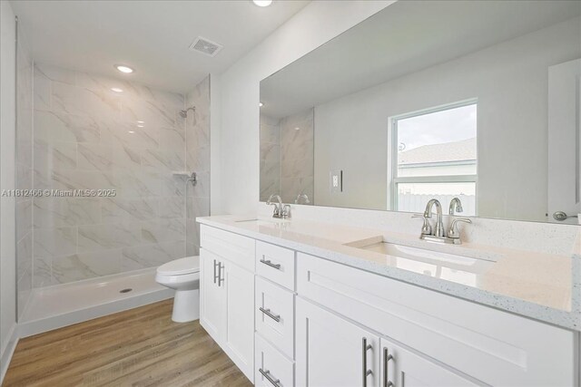 1119 NW 19th St, Cape Coral, FL 33993 - bathroom with double vanity, a marble finish shower, wood finished floors, and recessed lighting