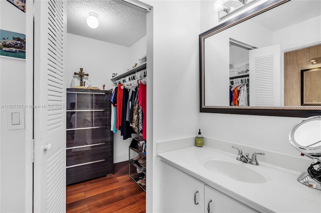 2260 SW 84th Way, Miramar, FL 33025 - bathroom featuring vanity, wood finished floors, a spacious closet, and a textured ceiling