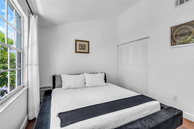 2260 SW 84th Way, Miramar, FL 33025 - bedroom featuring wood finished floors, a textured ceiling, and a closet