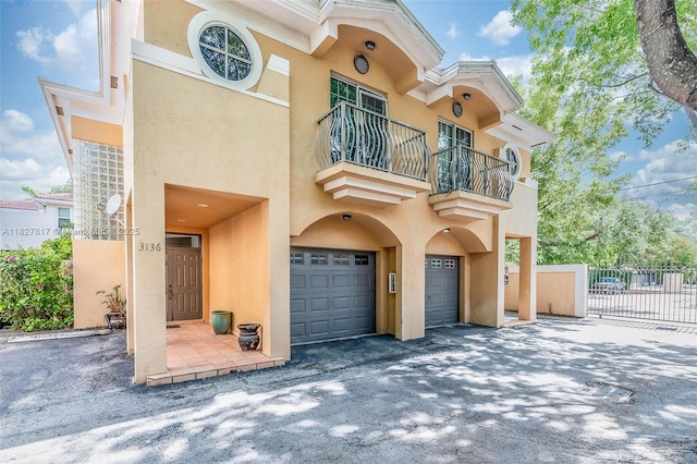 3136 Virginia St, Miami, FL 33133 - view of front of property with a garage, stucco siding, a balcony, and driveway