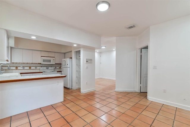 3136 Virginia St, Miami, FL 33133 - kitchen featuring white appliances, a peninsula, light tile patterned flooring, recessed lighting, and backsplash