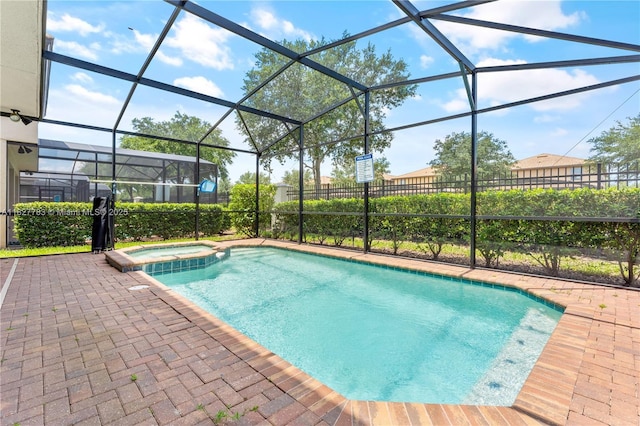 1892 Gobi Dr, Kissimmee, FL 3474 - view of swimming pool featuring a pool with connected hot tub, glass enclosure, and a patio area